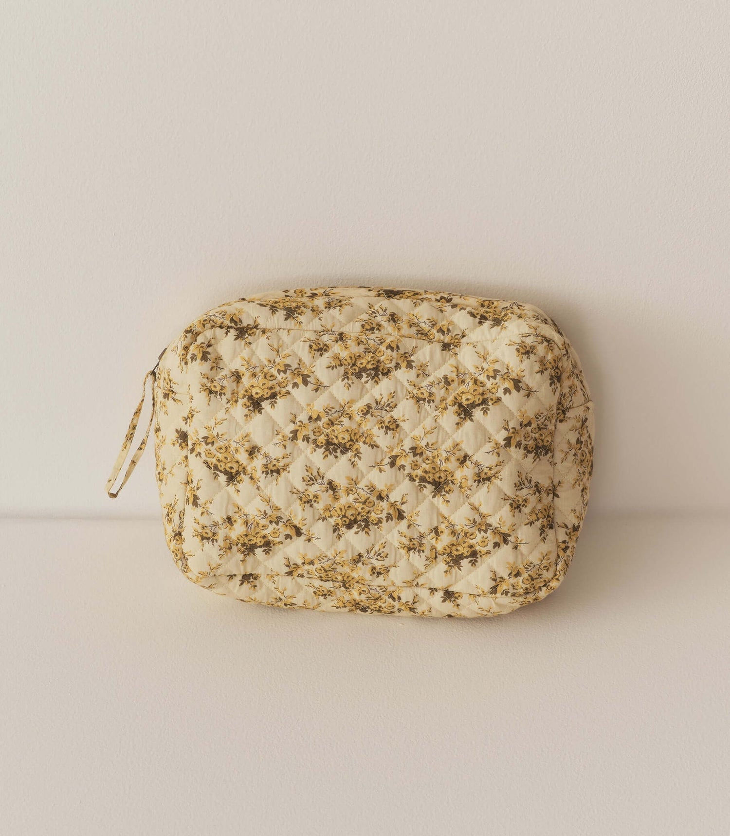 Quilted floral pouch bag in cream and gold, perfect for storing cosmetics and small essentials.
